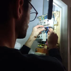 Électricien qui met en conformité un tableau électrique.